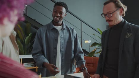 black man discussing project with team of colleagues at meeting