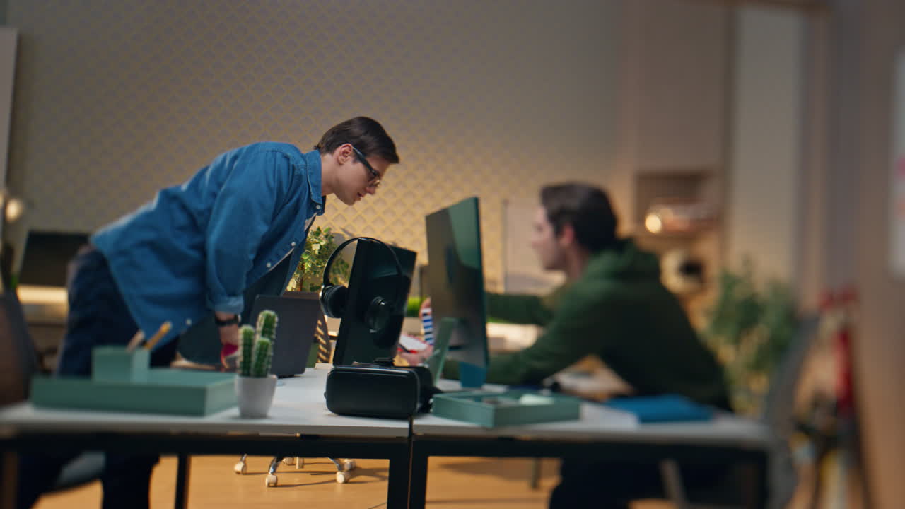 집중된 프리랜서들이 사무실에서 함께 일하는 흐릿한 효과. 남자가 동료에게 묻습니다.