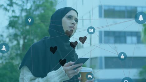 Netzwerk-Aus-Digitalen-Symbolen-Und-Mehreren-Schwarzen-Herzsymbolen-Schwebende-Frau-Im-Hijab,-Die-Ein-Smartphone-Hält