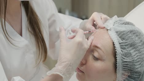 cosmetologist performing facial injection procedure