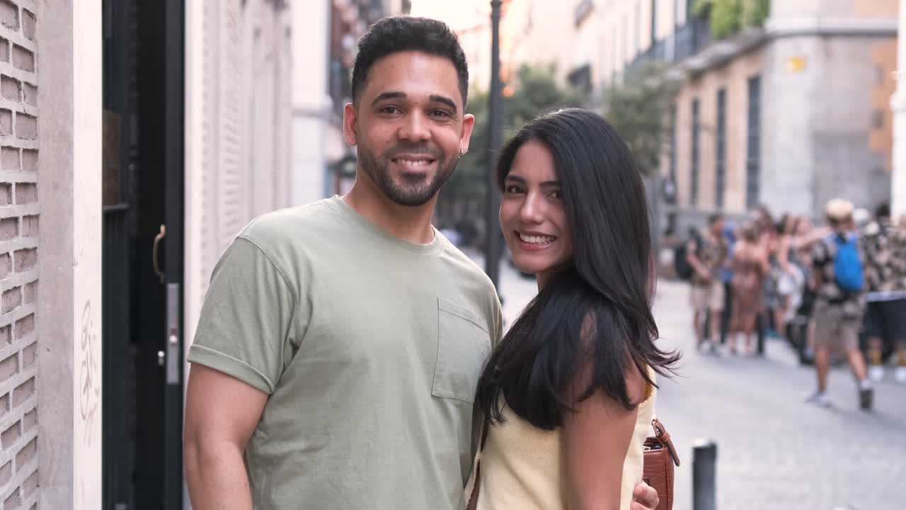 Happy couple in standing together and posing in city during daytime
