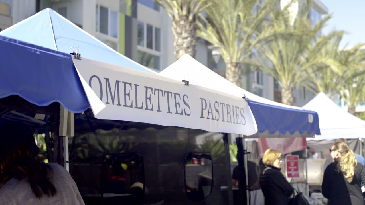 A food stall with a sign for omelettes and pastries at an outdoor market