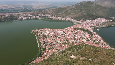 Clip-Aéreo-Sobre-Una-Montaña-Y-La-Ciudad-Y-El-Lago-De-Kastoria,-En-El-Norte-De-Grecia