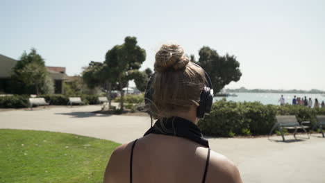 stylish young woman rollerblading in downtown park while listening to music in headphones (cinematic slow motion)