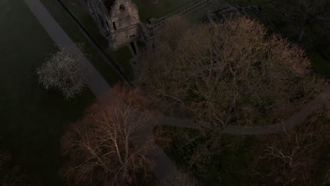 aerial tilt reveal shot of kirkstall abbey in yorkshire, england at dawn