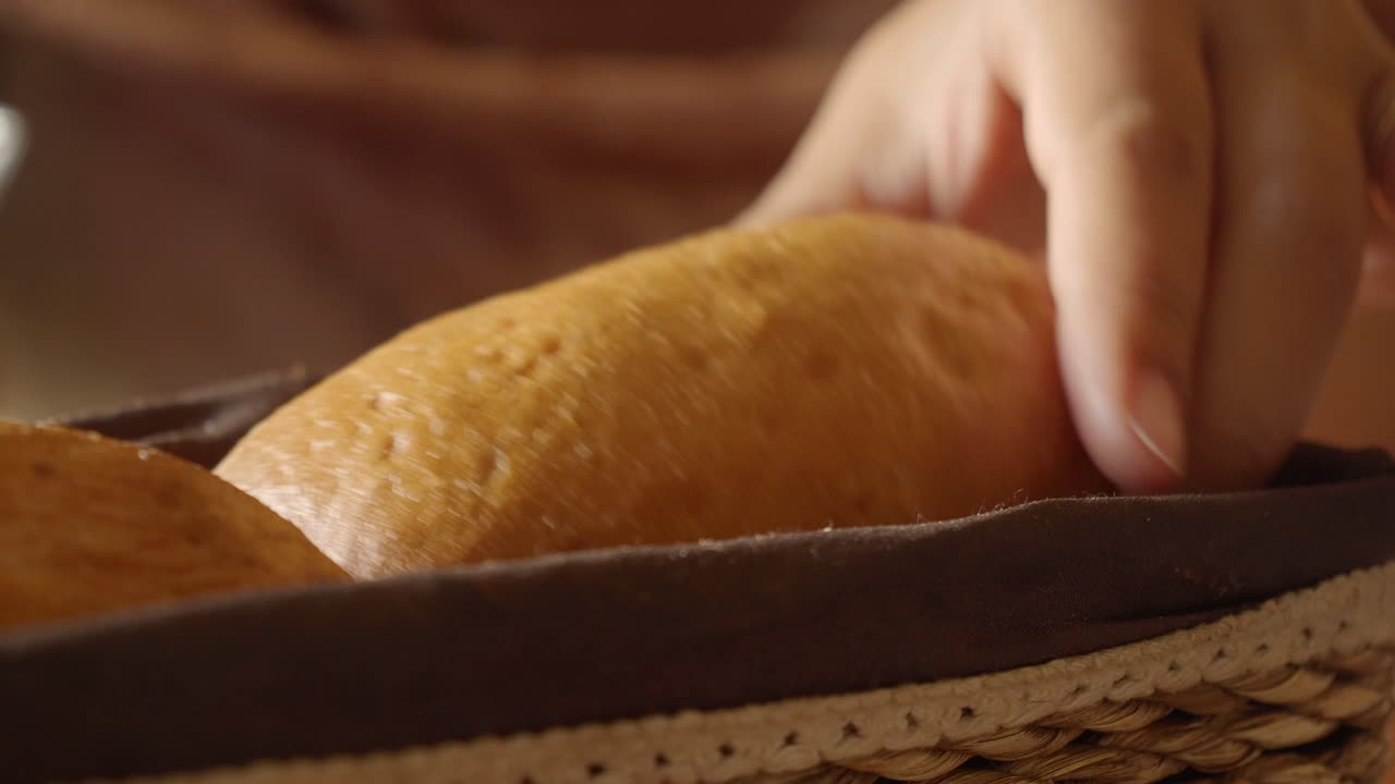Woman picking bread from basket