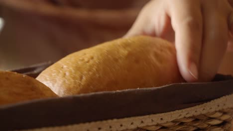 woman picking bread from basket