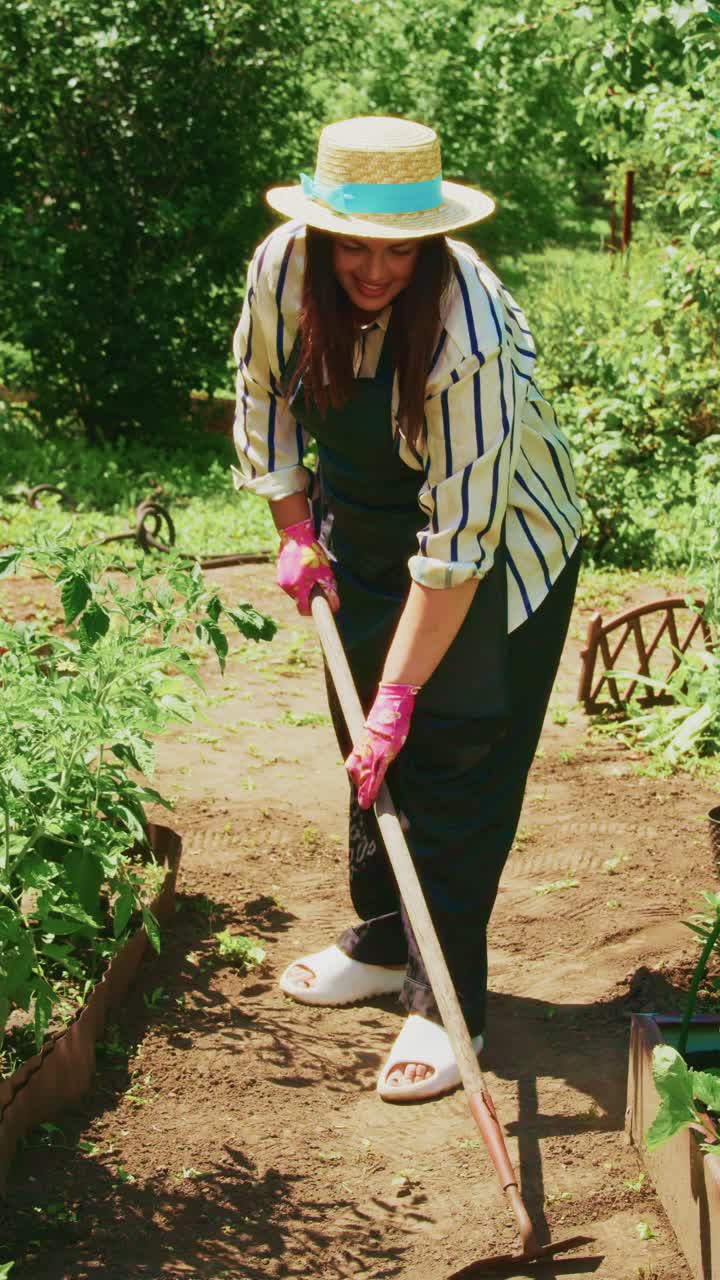 A Gardener Tending to Vegetable Beds with a Hoe in a Flourishing Garden, Embracing the Beauty of Nature and Hard Work Under the Bright Sunlight
