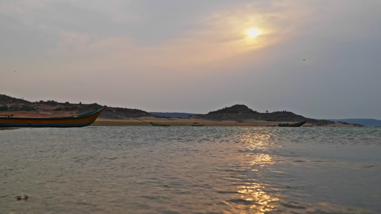 early morning Sun with boats and water at vizag colony, nagarjuna sagar backwater, telangana, india. day time, stable shot, 4k.