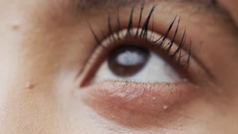 Eye-of-biracial-woman-with-dark-curly-hair,-slow-motion