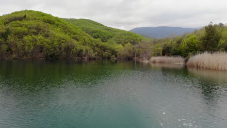 video de drone sobre el lago ángulo bajo montaña nublado día de verano montañas ascendentes