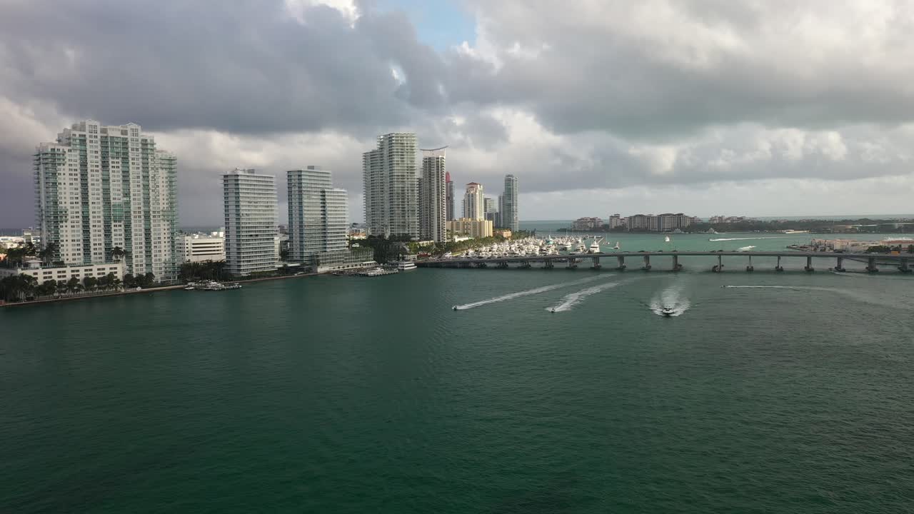 lanchas rápidas sobre el agua en la zona del puerto de miami con edificios en segundo plano.