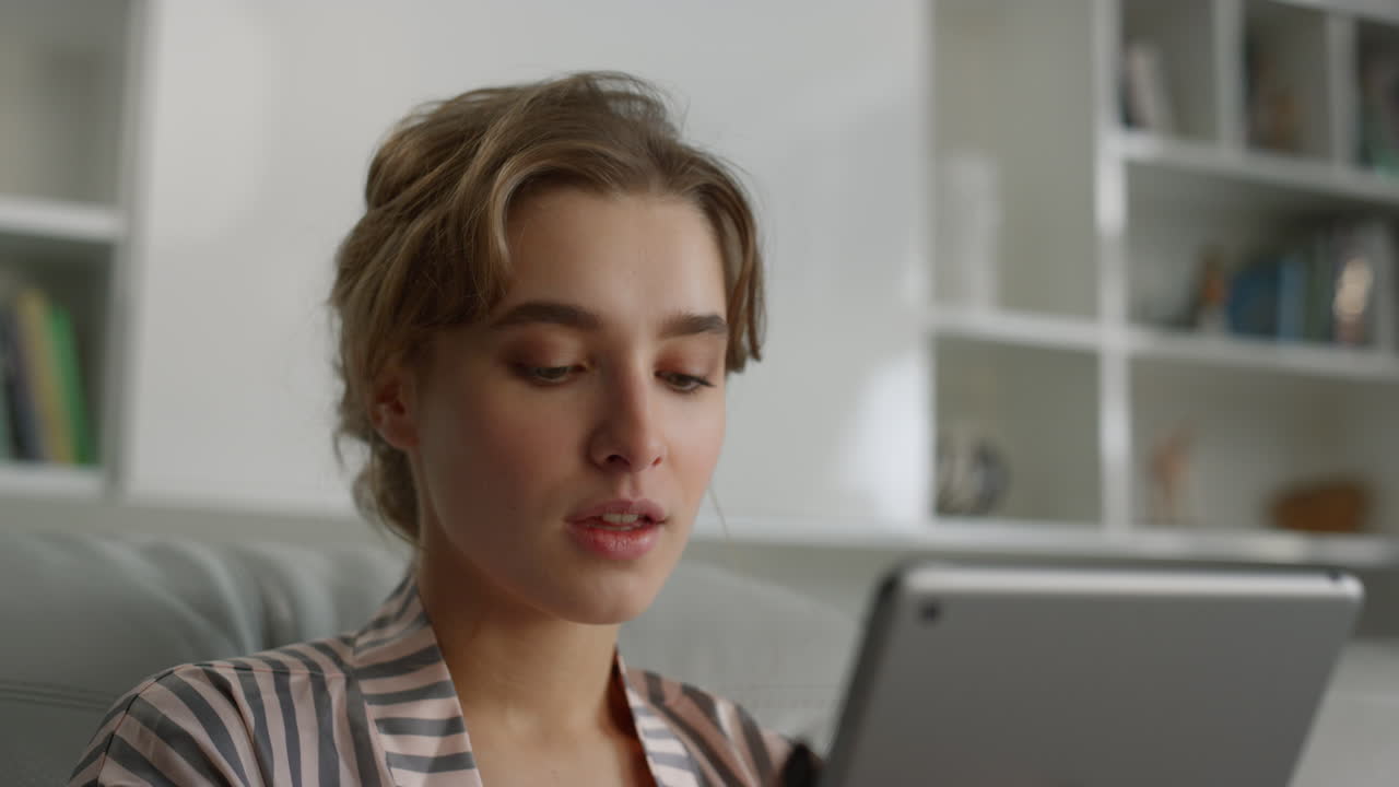 gerente de primer plano sosteniendo una computadora digital de tableta en un lugar de trabajo remoto en pijama.