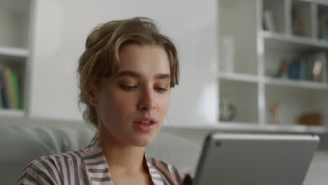 gerente de primer plano sosteniendo una computadora digital de tableta en un lugar de trabajo remoto en pijama.