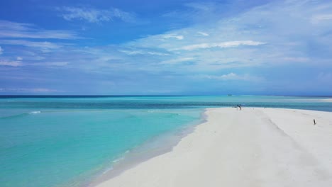 Paradise-white-beach-with-untouched-sand-washed-gently-by-calm-clear-flows-of-turquoise-lagoon-under-bright-cloudy-sky-in-Barbados