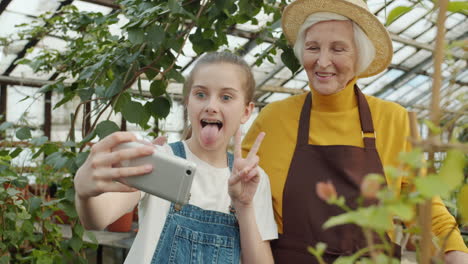 granddaughter and grandma taking a selfie in a greenhouse