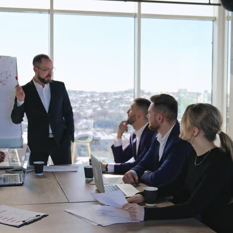 business meeting in the office. manager talks about the curve on the chart. business people discuss the ideas in the big light office