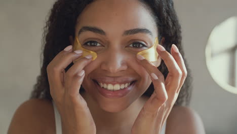 woman applying gold eye patches