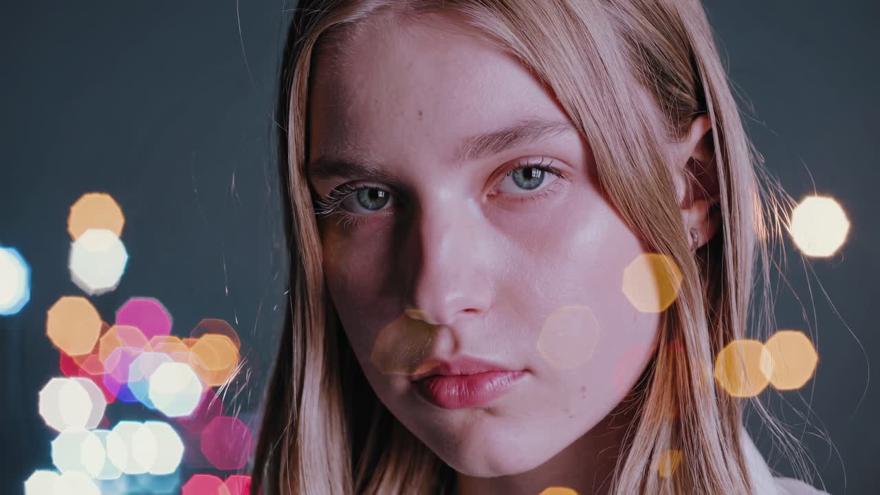 Close-up video still of a pensive woman with soft lighting and bokeh effect, capturing a dreamy