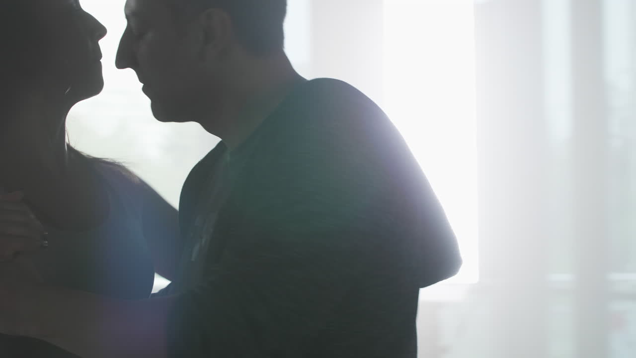 Couple dancing near a window
