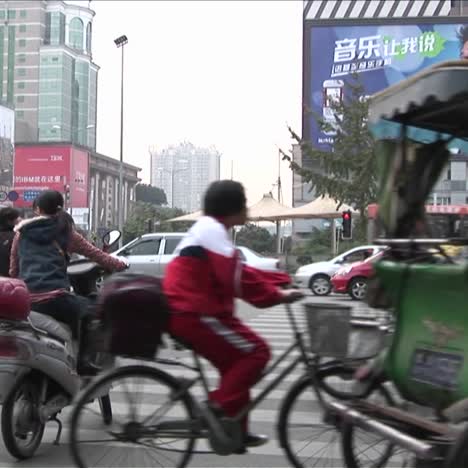 Auf-Einer-Pekinger-China-Straße-Mit-Modernen-Werbetafeln-Im-Hintergrund-Ziehen-Große-Mengen-An-Verkehr-Vorbei