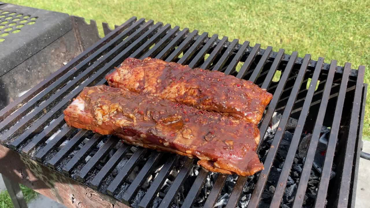 Cảnh quay video sườn nướng BBQ đang được nấu trên vỉ nướng