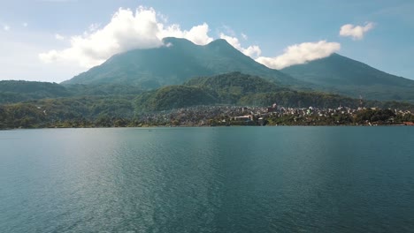 drone aerial flying over the beautiful blue lake atitlan in guatemala - mountains and volcanoes landscape