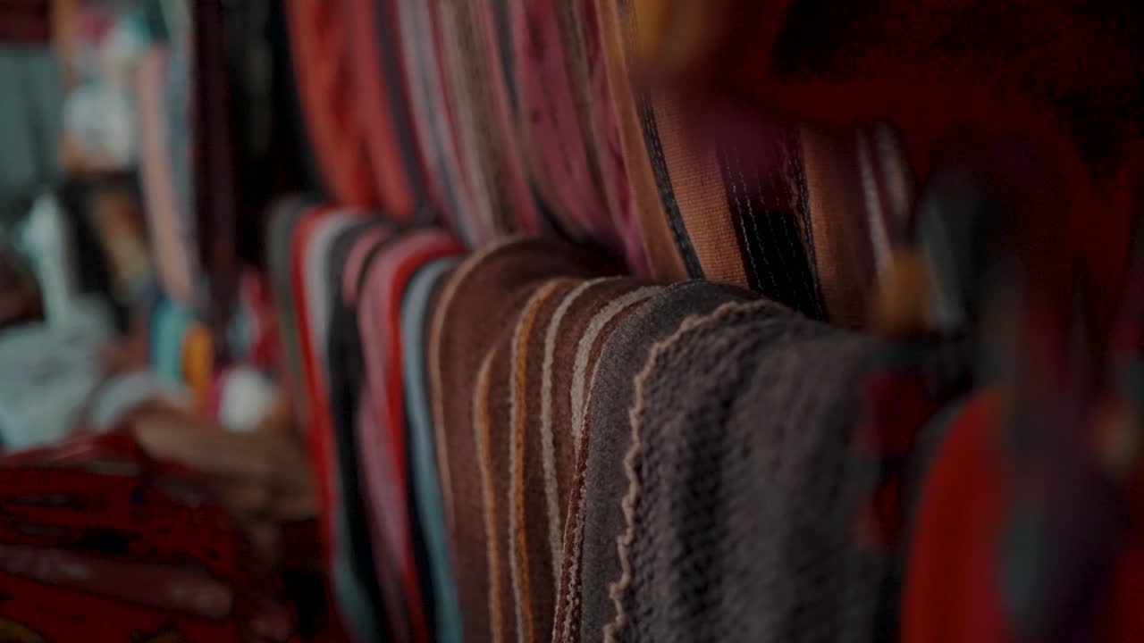 textiles guatemaltecos hechos a mano en la tienda de souvenirs cerca de antigua, guatemala, américa central - enfoque en rack