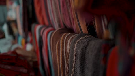 textiles guatemaltecos hechos a mano en la tienda de souvenirs cerca de antigua, guatemala, américa central - enfoque en rack