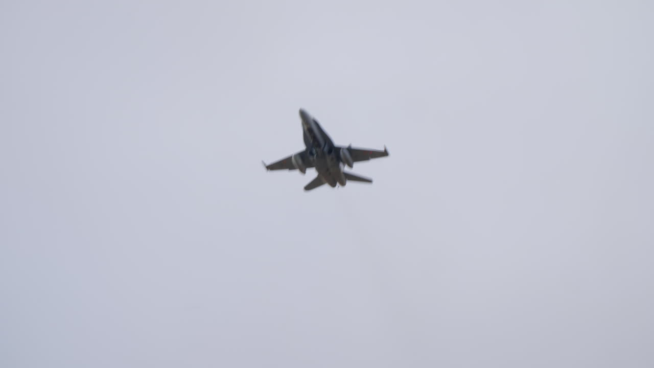 Powerful Fighter Jet Flying Overhead Against a Cloudy Sky