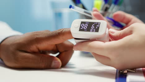 medical specialist takes oxygen saturation measurement and checking vital signs