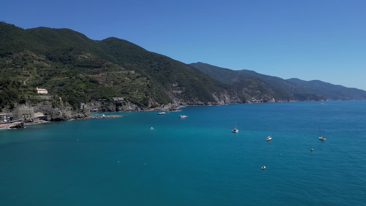 Drone captures a wide-angle aerial view of the blue lake, with hotels and houses nestled beside the mountains in Cinque Terre