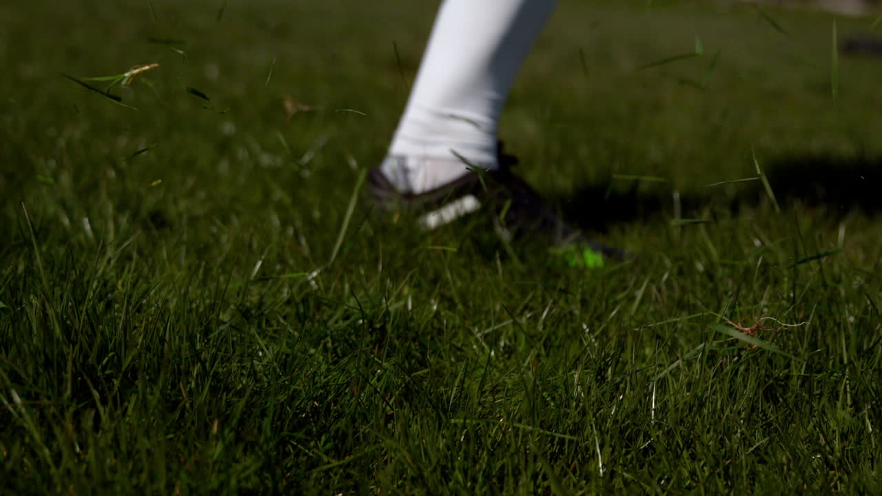 Football player kicking the ball on grass