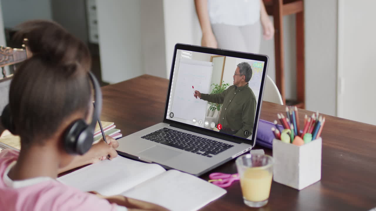 estudiante afroamericana en una computadora portátil aprendiendo en línea con un profesor masculino biracial
