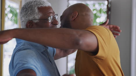 Loving-Senior-Father-Hugging-Adult-Son-Indoors-At-Home