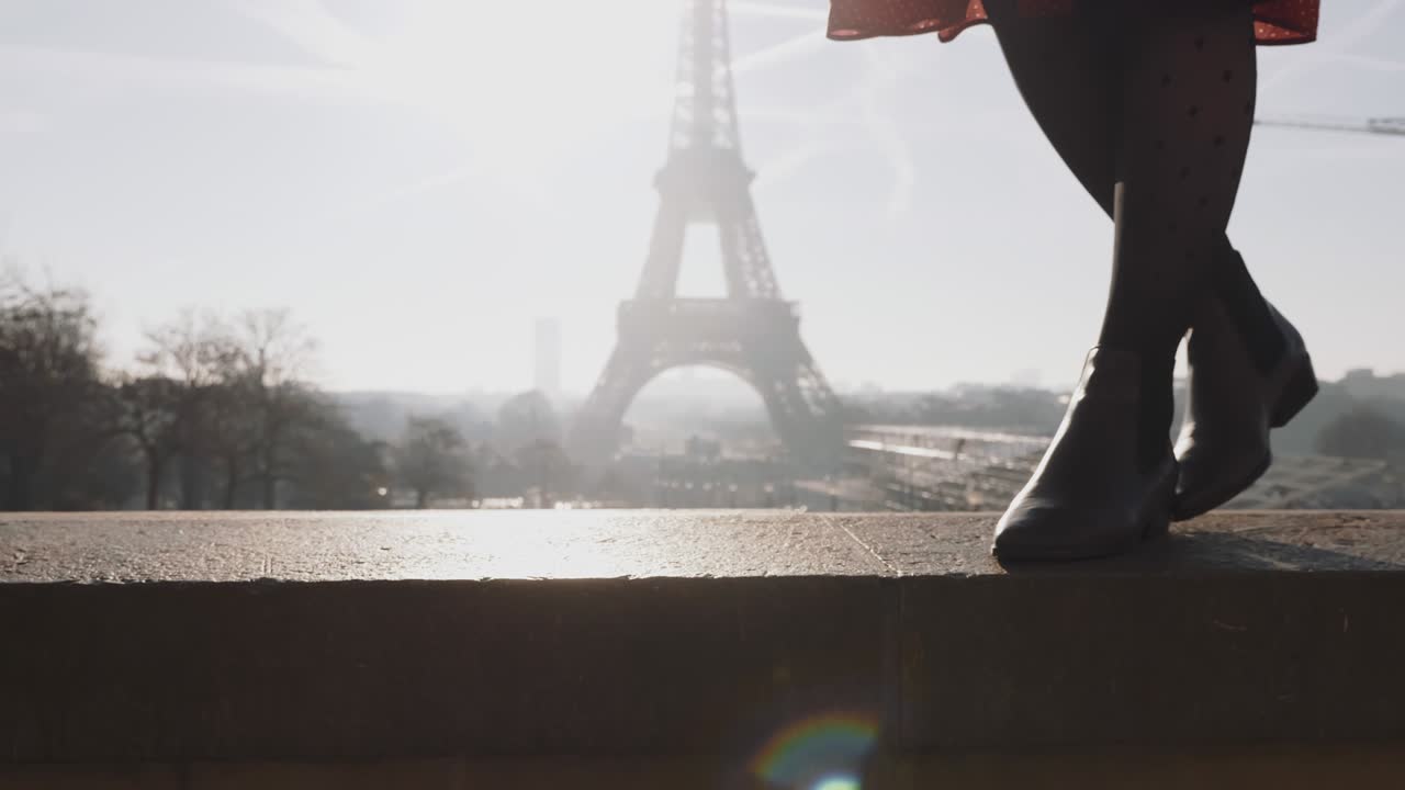 은 드레스를 입은 아름다운 미소 짓는 여성이 은 에펠탑 근처에서 포즈를 취하고 있습니다.