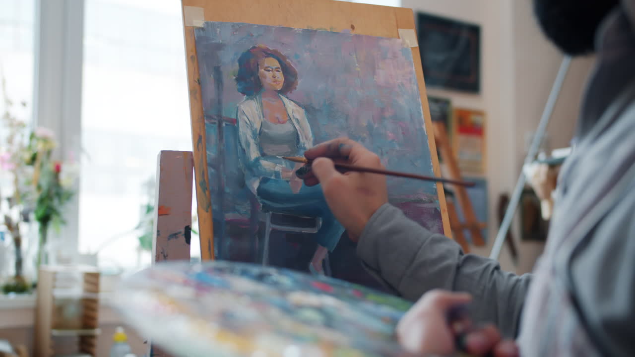 Artist painting a portrait of a woman in an art studio