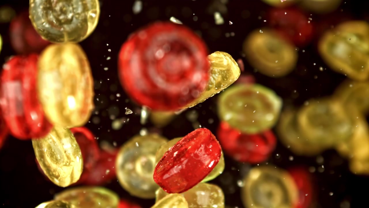 Caramelle rosse e gialle che cadono al rallentatore