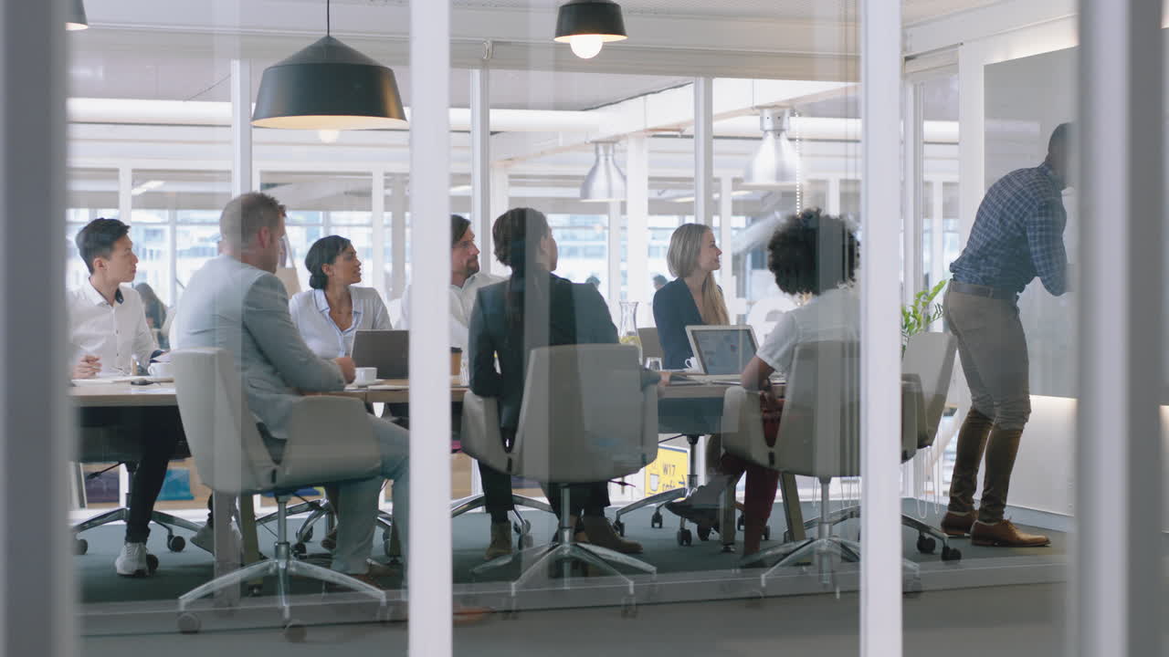 group of business people meeting in boardroom team leader man presenting ideas on whiteboard discussing strategy with colleagues in office training presentation 4k