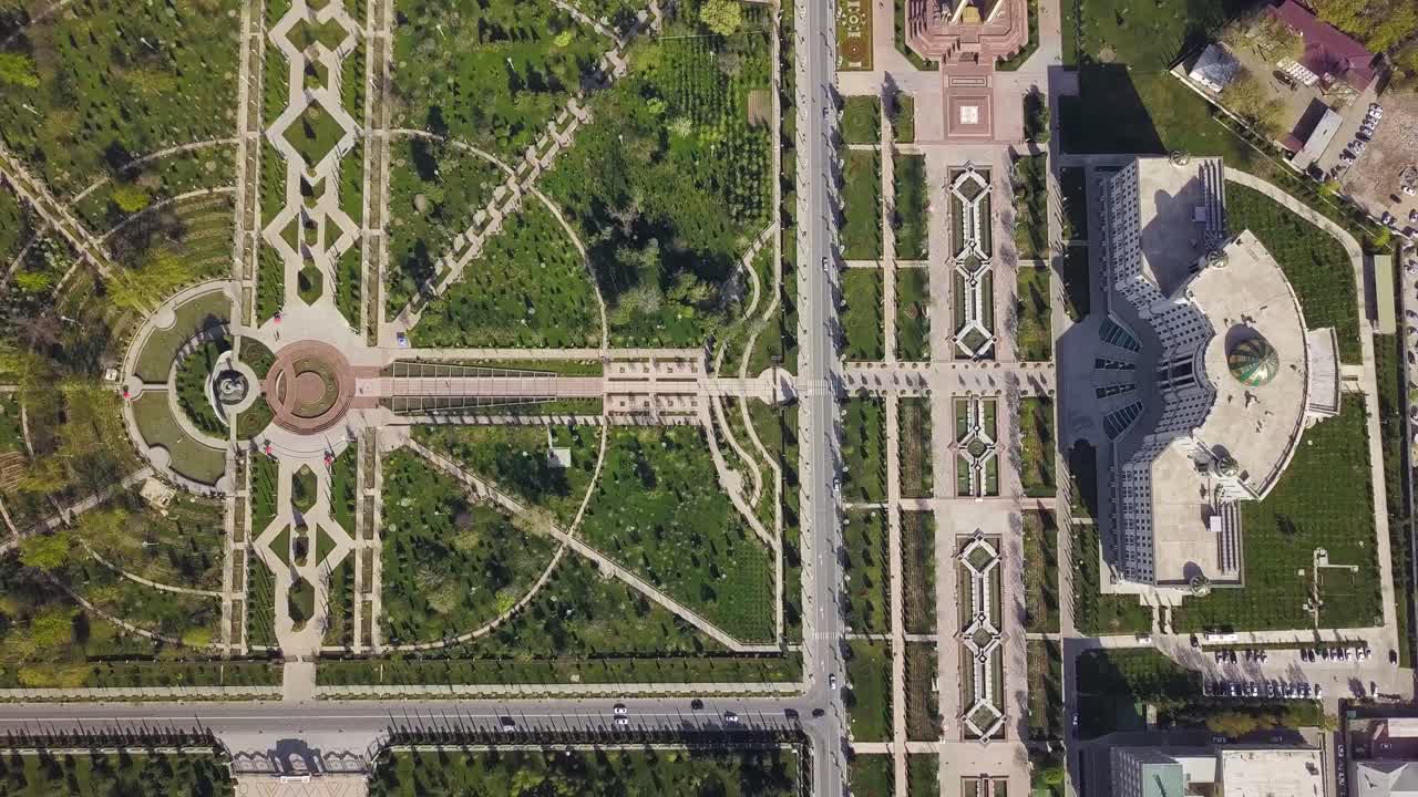 toma cenital ascendente aérea en la ciudad de dushanbe, tayikistán sobre el parque rudaki y la biblioteca nacional