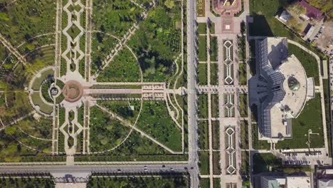 Toma-Cenital-Ascendente-Aérea-En-La-Ciudad-De-Dushanbe,-Tayikistán-Sobre-El-Parque-Rudaki-Y-La-Biblioteca-Nacional