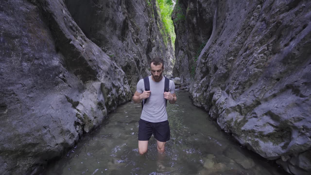 바위 사이에 있는 하천을  ⁇ 고 있는 맨발의 남자.