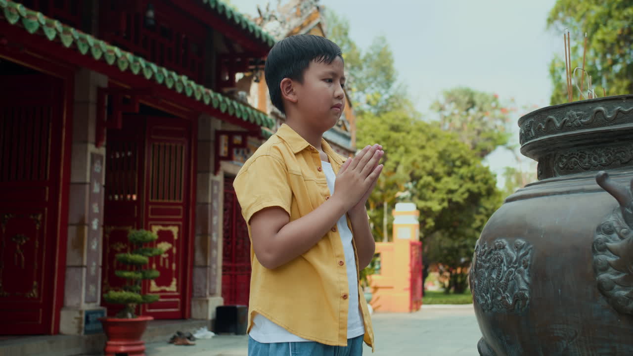 Asian Teenager Praying by Ancient Burner
