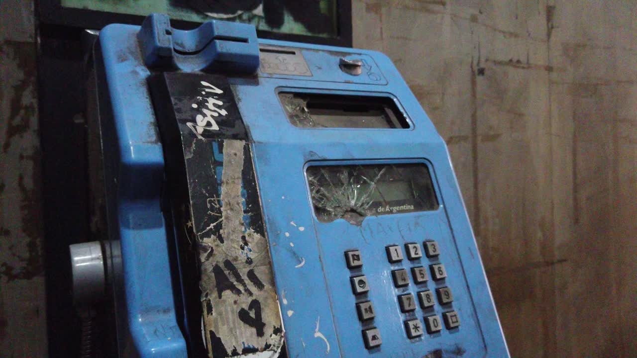 Vintage telephone, broken machine closeup, public phone, vandalized at city streets