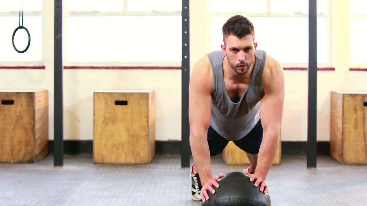 hombre en forma haciendo flexiones en el estudio de crossfit