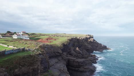 Toma-Aérea-De-La-Asombrosa-Bahía-Azul-Cerca-Del-Faro-Del-Pueblo-De-Ajo,-Cantabria,-España