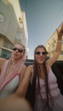 two women enjoying a convertible ride