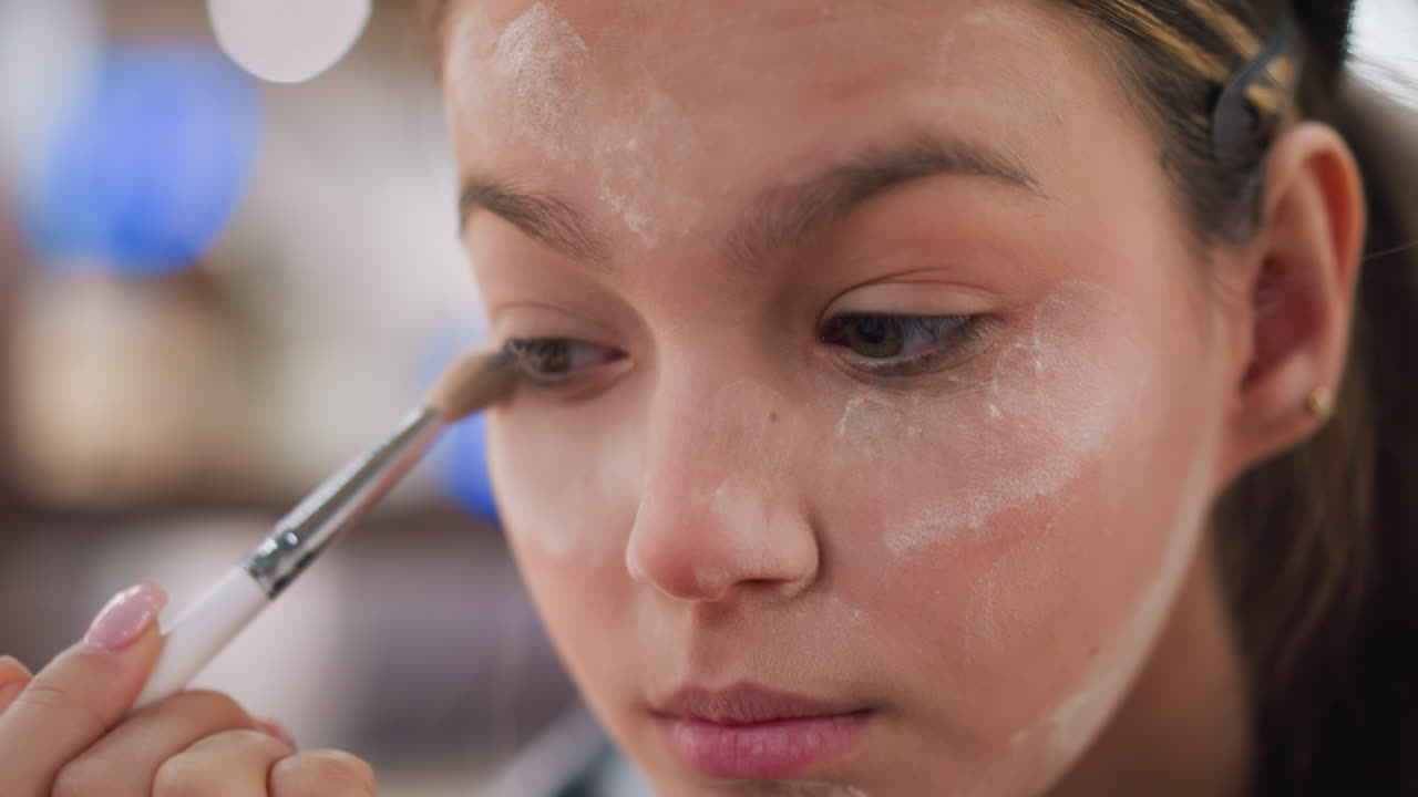 vista de primer plano de una dama aplicando maquillaje alrededor de sus ojos con un pincel, centrarse en la técnica de maquillaje delicada, la mezcla de polvo y el proceso de maquilaje de ojos para la rutina de belleza y cosméticos