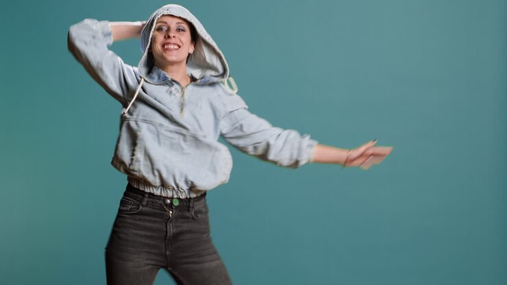 Young woman dancing in studio wearing denim jacket