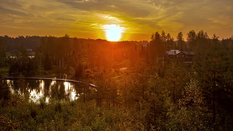 static shot of sunrise in timelapse with bungalows surrounded by rural meadows